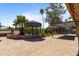 Lush backyard oasis featuring tiki huts, brick pavers, mature trees, and tropical landscaping at 848 S Revolta Cir, Mesa, AZ 85208