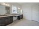 Double vanity bathroom with granite countertops and a large mirror at 16417 W Desert Mirage Dr, Surprise, AZ 85388