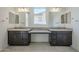 Double vanity bathroom with granite countertops and a large mirror at 16417 W Desert Mirage Dr, Surprise, AZ 85388