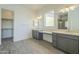 Double vanity bathroom with gray cabinets and walk-in shower at 16425 W Desert Mirage Dr, Surprise, AZ 85388