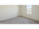 Bright bedroom with gray carpet and a large window at 16425 W Desert Mirage Dr, Surprise, AZ 85388