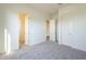 Spacious bedroom with grey carpet, neutral walls, and multiple doors at 16425 W Desert Mirage Dr, Surprise, AZ 85388