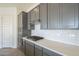 Modern kitchen with gray cabinets, white subway tile backsplash and gas cooktop at 16425 W Desert Mirage Dr, Surprise, AZ 85388