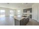 Open kitchen with gray cabinets, island, and views into living room at 16425 W Desert Mirage Dr, Surprise, AZ 85388