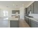 Modern kitchen with gray cabinets, white subway tile backsplash, and large island at 16425 W Desert Mirage Dr, Surprise, AZ 85388