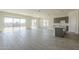 Open living room and kitchen with tile flooring and sliding glass doors to backyard at 16425 W Desert Mirage Dr, Surprise, AZ 85388