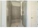 Walk-in shower with gray tile and built-in seat at 16425 W Desert Mirage Dr, Surprise, AZ 85388