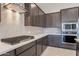 Modern kitchen with dark cabinets and a herringbone tile backsplash at 266 S 165Th Ave, Goodyear, AZ 85338