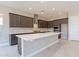 Modern kitchen with dark cabinets, quartz countertops, and stainless steel appliances at 266 S 165Th Ave, Goodyear, AZ 85338