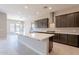 Open kitchen with island, stainless steel appliances, and tile backsplash at 266 S 165Th Ave, Goodyear, AZ 85338