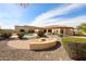 Expansive backyard with a pool, patio, fire pit, and lush desert landscaping at 19517 W Huron Ln, Buckeye, AZ 85326