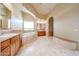 Bright bathroom featuring double sinks, a soaking tub, and a glass-enclosed shower area for ultimate comfort and relaxation at 19517 W Huron Ln, Buckeye, AZ 85326