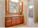 Bathroom featuring wooden cabinets and a decorative backsplash around the sink and mirror at 19517 W Huron Ln, Buckeye, AZ 85326