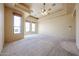 A spacious primary bedroom featuring large windows, high ceilings, and a ceiling fan providing a tranquil retreat at 19517 W Huron Ln, Buckeye, AZ 85326