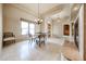 Dining room featuring chandelier lighting, large windows, and travertine flooring at 19517 W Huron Ln, Buckeye, AZ 85326