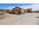 Wide driveway leads to a desert home with a three-car garage and separate garage at 19517 W Huron Ln, Buckeye, AZ 85326