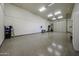 Large garage with epoxy floors, overhead lighting, and ample space for storage and projects at 19517 W Huron Ln, Buckeye, AZ 85326