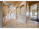 Elegant hallway with travertine floors, arches, and columns at 19517 W Huron Ln, Buckeye, AZ 85326