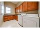 Well-lit laundry room with washer, dryer, countertops, and ample cabinet space at 19517 W Huron Ln, Buckeye, AZ 85326