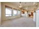 Bright living room featuring neutral walls, large windows with woven shades, and plush carpeting for added comfort at 19517 W Huron Ln, Buckeye, AZ 85326