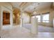 Open concept living room with travertine flooring, decorative columns, and natural lighting at 19517 W Huron Ln, Buckeye, AZ 85326