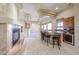 Cozy living room featuring fireplace, bar seating, and travertine tile flooring at 19517 W Huron Ln, Buckeye, AZ 85326