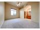 Large main bedroom with ceiling fan, neutral carpet, and en suite bathroom at 19517 W Huron Ln, Buckeye, AZ 85326