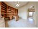 Home office features built-in shelving and spacious desk area, perfect for work or study with travertine floors at 19517 W Huron Ln, Buckeye, AZ 85326