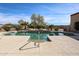 Outdoor pool with concrete decking, rock waterfall feature, and desert landscaping at 19517 W Huron Ln, Buckeye, AZ 85326