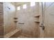 Shower featuring neutral tile and built-in shelving, offering both convenience and style, along with a grab bar at 19517 W Huron Ln, Buckeye, AZ 85326