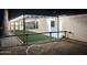 Night view of backyard with pergola, artificial turf, and wood fence at 1113 N Cota Ln, Coolidge, AZ 85128