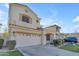 Two-story house with tan exterior, two-car garage, and landscaped yard at 2067 W Periwinkle Way, Chandler, AZ 85248