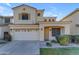 Two-story house with tan exterior, two-car garage, and landscaped yard at 2067 W Periwinkle Way, Chandler, AZ 85248