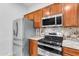 Kitchen with stainless steel appliances and wood cabinets at 2067 W Periwinkle Way, Chandler, AZ 85248