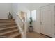 Bright entryway featuring light wood floors, staircase, white walls, and a stylish potted plant accent at 2200 N Iowa St, Chandler, AZ 85225