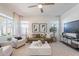 Open-concept living room featuring neutral tones, modern furniture, a ceiling fan, and light wood floors at 2200 N Iowa St, Chandler, AZ 85225