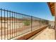 View of backyard featuring wrought iron fence offering security and boundary definition under a clear blue sky at 5656 N 205Th Ln, Buckeye, AZ 85396