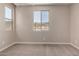 A neutral-toned room features carpeting and natural light from the surrounding windows at 5656 N 205Th Ln, Buckeye, AZ 85396