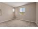 A neutral-toned room features carpeting and natural light from the surrounding windows at 5656 N 205Th Ln, Buckeye, AZ 85396