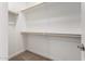 A walk-in closet with neutral carpeting and built in wood rod for hanging clothes at 5656 N 205Th Ln, Buckeye, AZ 85396