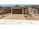 A quaint single-story home with a two-car garage, beautiful desert landscaping, and a paved driveway at 5656 N 205Th Ln, Buckeye, AZ 85396