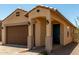Charming home with a two-car garage, covered porch, and manicured desert landscaping at 5656 N 205Th Ln, Buckeye, AZ 85396