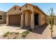 Inviting home with a two-car garage, covered porch, and well-maintained desert landscaping at 5656 N 205Th Ln, Buckeye, AZ 85396