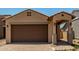 Inviting single-story home featuring a two-car garage, covered entryway, and desert landscaping at 5656 N 205Th Ln, Buckeye, AZ 85396