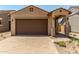 Charming single-story home with a two-car garage, paved driveway, and low-maintenance desert landscaping at 5656 N 205Th Ln, Buckeye, AZ 85396