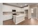 Bright kitchen features white cabinetry, stainless appliances, and a center island at 5656 N 205Th Ln, Buckeye, AZ 85396
