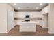 Bright kitchen features white cabinetry, stainless appliances, and a center island at 5656 N 205Th Ln, Buckeye, AZ 85396