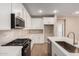 Bright kitchen features white cabinetry, stainless appliances, and a center island at 5656 N 205Th Ln, Buckeye, AZ 85396