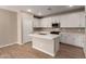 Bright kitchen features white cabinetry, stainless appliances, and a center island at 5656 N 205Th Ln, Buckeye, AZ 85396