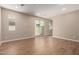 Bright living room boasts wood-look tile flooring, recessed lighting, and a sliding glass door to the backyard at 5656 N 205Th Ln, Buckeye, AZ 85396